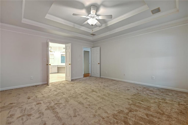 unfurnished bedroom featuring ceiling fan, light colored carpet, a raised ceiling, and crown molding