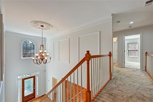 hallway featuring an inviting chandelier, light carpet, and ornamental molding