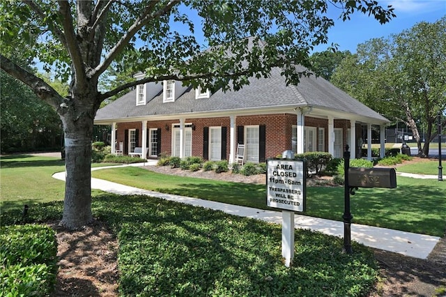 new england style home with a porch and a front lawn