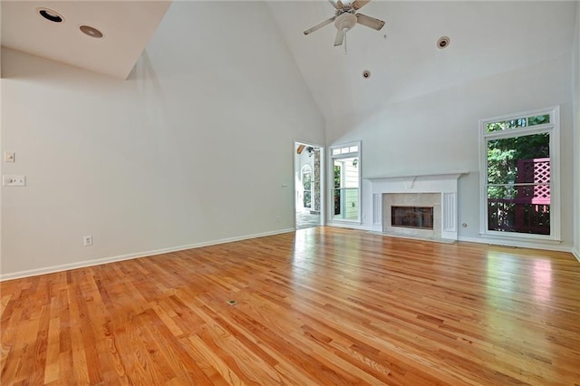 unfurnished living room featuring light wood-type flooring, high vaulted ceiling, and ceiling fan