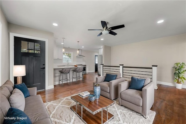 living room with sink, dark hardwood / wood-style floors, and ceiling fan