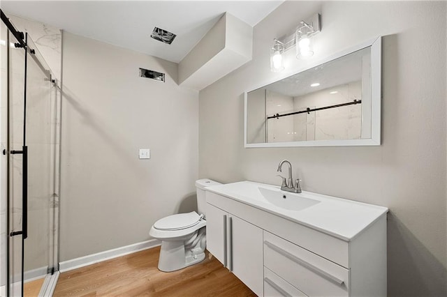 bathroom with vanity, an enclosed shower, hardwood / wood-style floors, and toilet