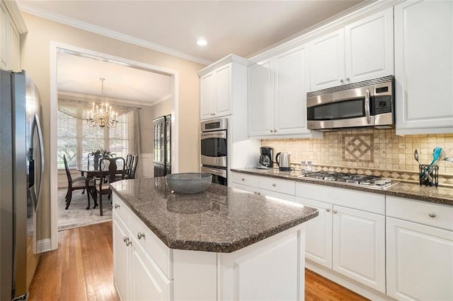 4653 Glory Maple Trce, Powder Springs, GA 30127 - kitchen with appliances with stainless steel finishes, a chandelier, light wood finished floors, crown molding, and white cabinets