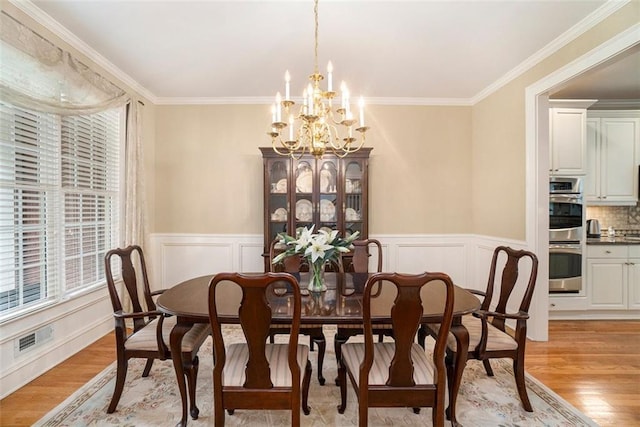 4653 Glory Maple Trce, Powder Springs, GA 30127 - dining space with a chandelier, light wood-style flooring, ornamental molding, wainscoting, and a decorative wall