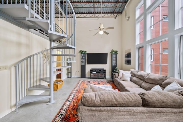 572 Edgewood Ave SE Unit 303, Atlanta, GA 30312 - living room featuring a towering ceiling, stairway, a ceiling fan, baseboards, and finished concrete flooring