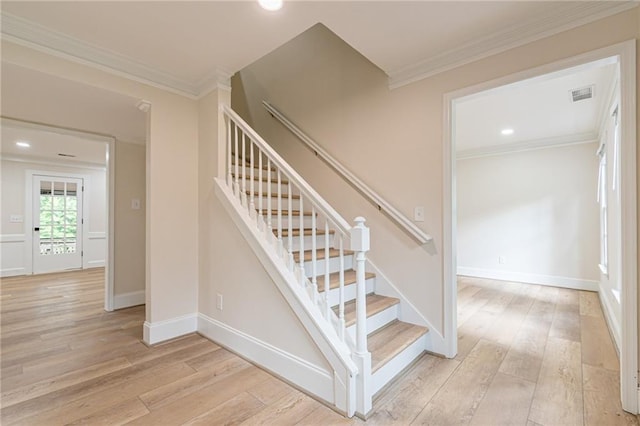 stairway with crown molding and wood-type flooring