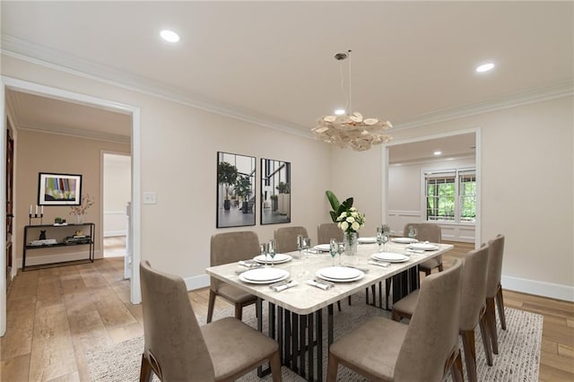 dining space with light hardwood / wood-style flooring, a notable chandelier, and ornamental molding