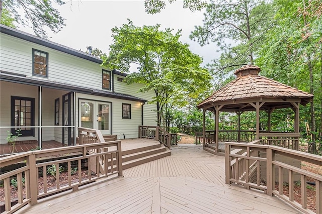 wooden deck featuring a gazebo and a sunroom