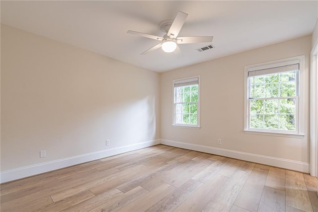 empty room featuring light wood-type flooring, ceiling fan, and plenty of natural light