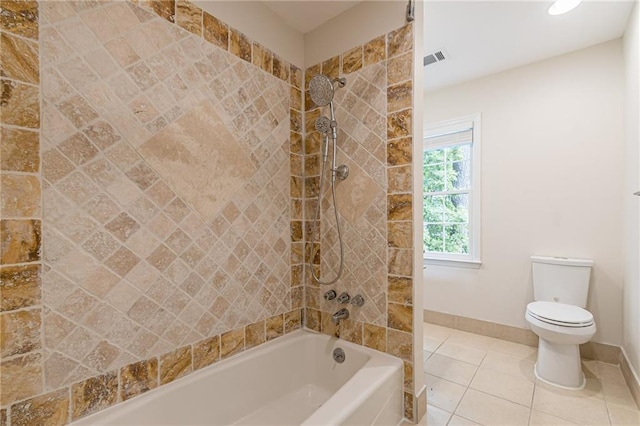 bathroom with toilet, tile patterned floors, and tiled shower / bath combo