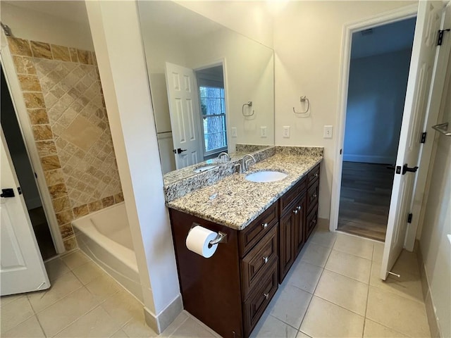 bathroom featuring vanity, a bath, and tile patterned flooring