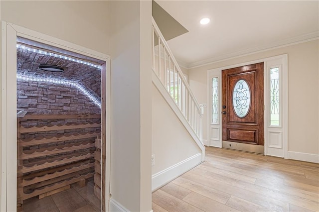 entrance foyer featuring crown molding and light wood-type flooring