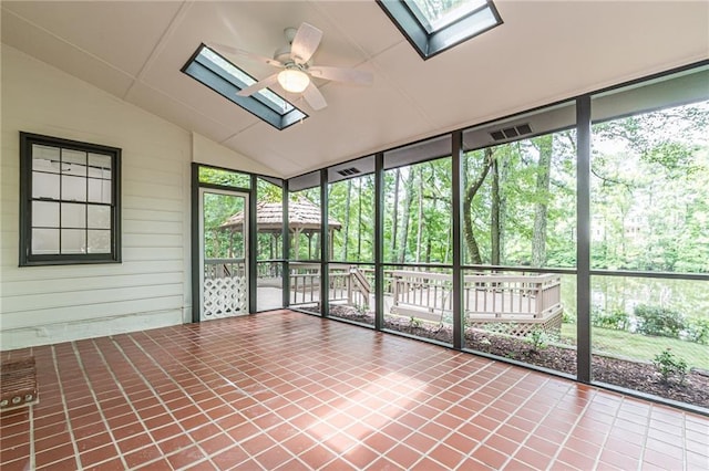 unfurnished sunroom with ceiling fan and a skylight