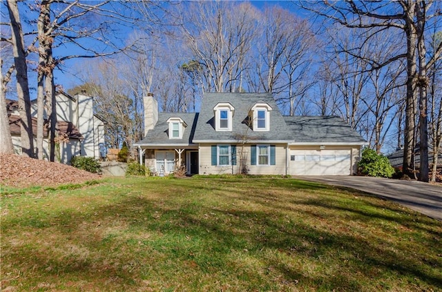 cape cod house with a front yard, a chimney, concrete driveway, and an attached garage