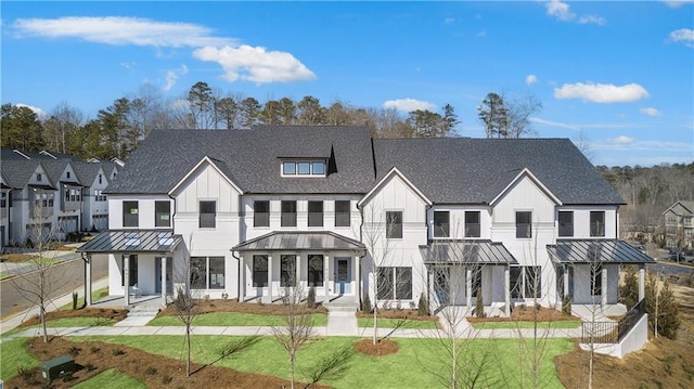 modern inspired farmhouse with metal roof, a front yard, and a standing seam roof