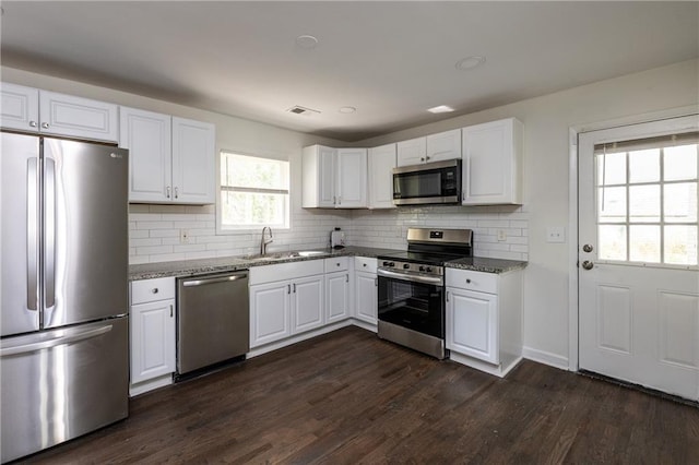 kitchen featuring white cabinets, sink, stone counters, and appliances with stainless steel finishes