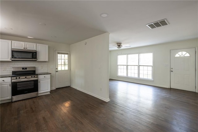 kitchen with dark hardwood / wood-style floors, white cabinets, backsplash, ceiling fan, and stainless steel appliances