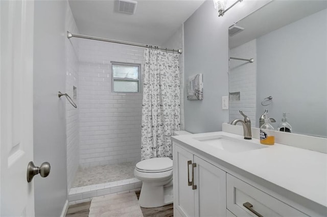 bathroom featuring vanity, toilet, hardwood / wood-style floors, and walk in shower