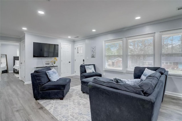 living room with crown molding and light hardwood / wood-style flooring