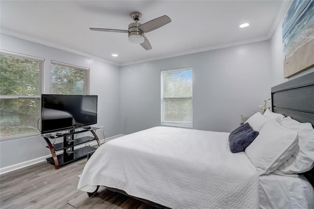 bedroom with crown molding, ceiling fan, hardwood / wood-style floors, and multiple windows