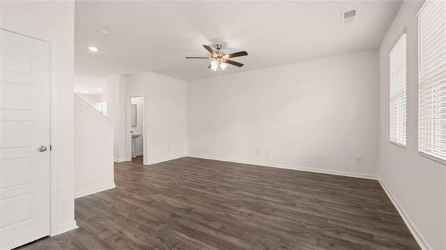 spare room featuring ceiling fan, a healthy amount of sunlight, and dark hardwood / wood-style floors