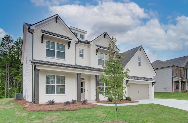 traditional-style home featuring metal roof, an attached garage, cooling unit, a standing seam roof, and a front yard