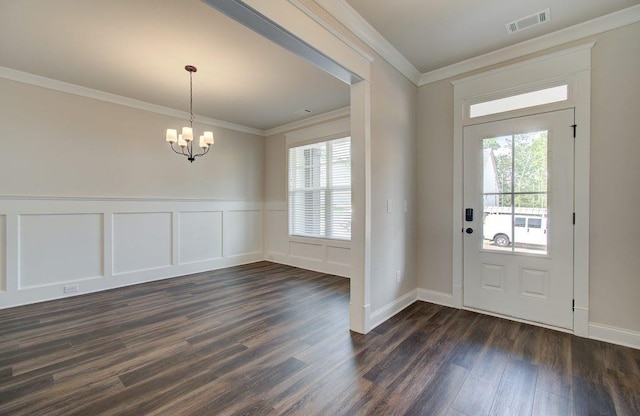 foyer entrance with ornamental molding, visible vents, dark wood finished floors, and an inviting chandelier