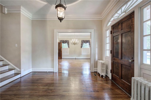 entryway with ornamental molding, radiator heating unit, and dark hardwood / wood-style flooring