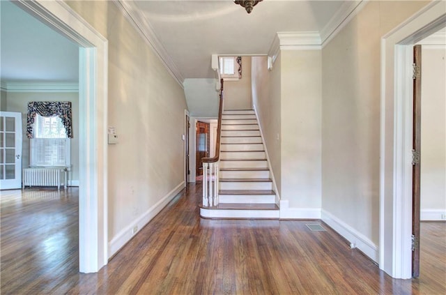 stairway featuring crown molding, wood-type flooring, and radiator