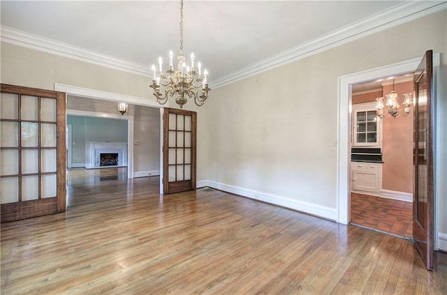 interior space featuring an inviting chandelier, ornamental molding, and hardwood / wood-style floors