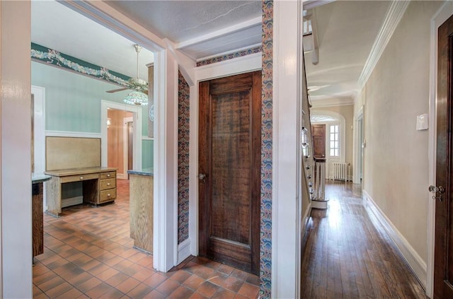 hall with ornamental molding, radiator heating unit, and dark hardwood / wood-style floors