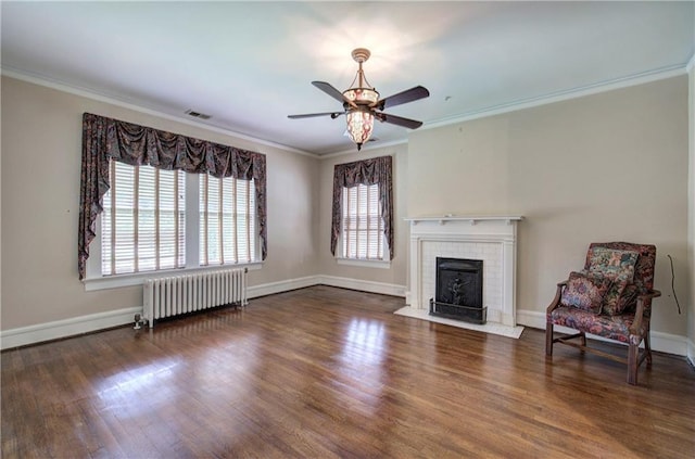 unfurnished living room featuring crown molding, dark hardwood / wood-style floors, radiator heating unit, and a fireplace