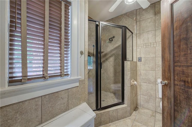 bathroom featuring tile walls, tile patterned flooring, ceiling fan, and walk in shower