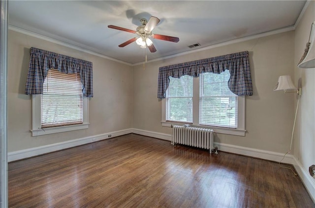 spare room featuring radiator, dark wood-type flooring, ornamental molding, and ceiling fan