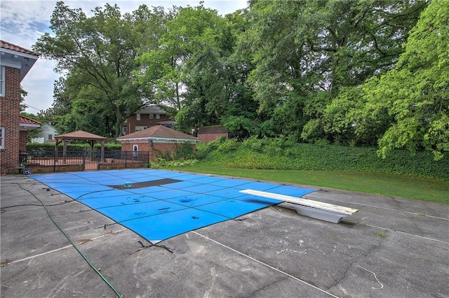 view of pool with a gazebo, a diving board, and a patio