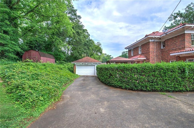 view of yard featuring a garage and a shed