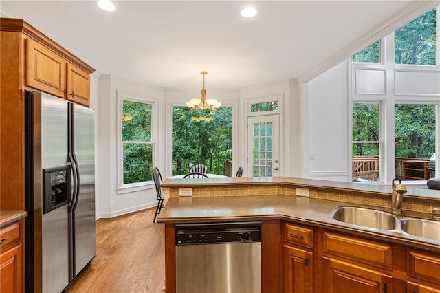5355 Highland Pine Ln, Mableton, GA 30126 - kitchen featuring appliances with stainless steel finishes, brown cabinets, a chandelier, healthy amount of natural light, and recessed lighting
