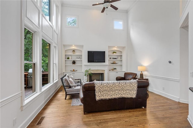 5355 Highland Pine Ln, Mableton, GA 30126 - living room with crown molding, healthy amount of natural light, a ceiling fan, a towering ceiling, and built in features