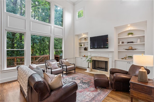 5355 Highland Pine Ln, Mableton, GA 30126 - living area with a high ceiling, built in features, light wood-type flooring, a high end fireplace, and ornamental molding