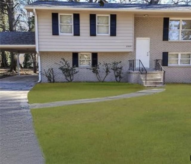 bi-level home featuring a front lawn and a carport