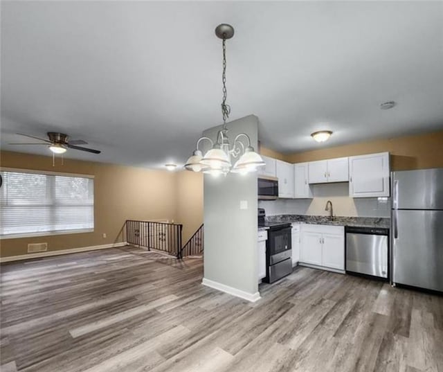 2900 Bradmoor Ct, Decatur, GA 30034 - kitchen with white cabinets, wood finished floors, stainless steel appliances, a sink, and open floor plan