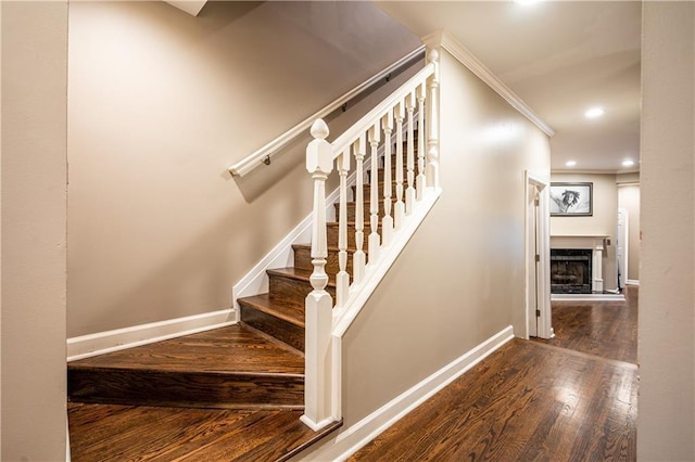 staircase with hardwood / wood-style floors and ornamental molding