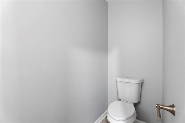 bathroom featuring toilet and baseboards