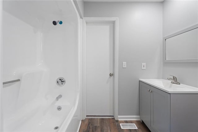 bathroom featuring vanity,  shower combination, wood finished floors, and visible vents