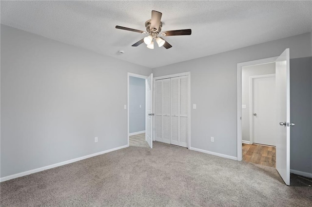 unfurnished bedroom featuring carpet flooring, a textured ceiling, and baseboards