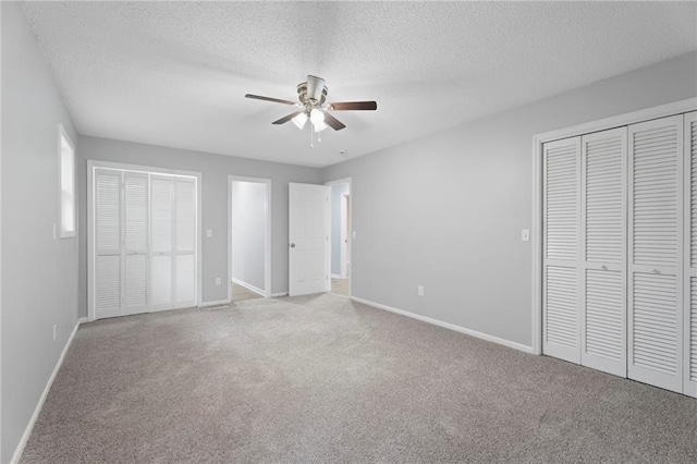 unfurnished bedroom with a textured ceiling, baseboards, and carpet flooring