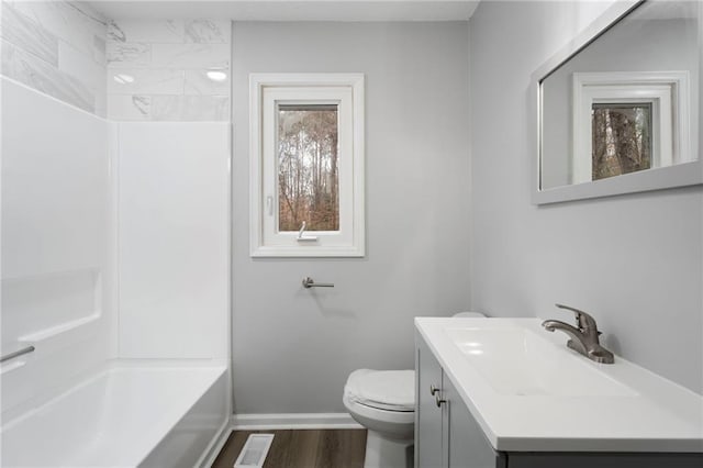 full bath featuring visible vents, toilet, vanity, wood finished floors, and baseboards