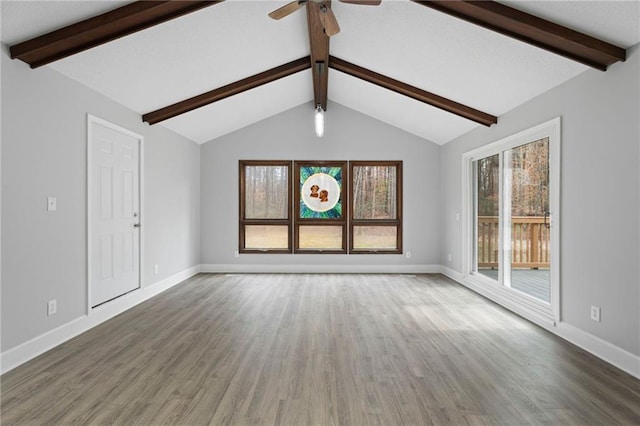 unfurnished living room with lofted ceiling with beams, a ceiling fan, baseboards, and wood finished floors