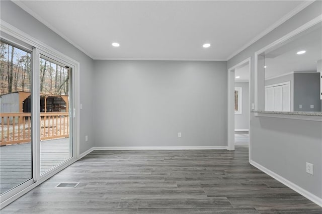 unfurnished room with ornamental molding, wood finished floors, visible vents, and baseboards