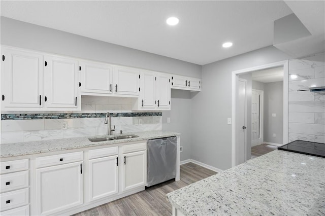 kitchen featuring stainless steel dishwasher, backsplash, a sink, and white cabinetry